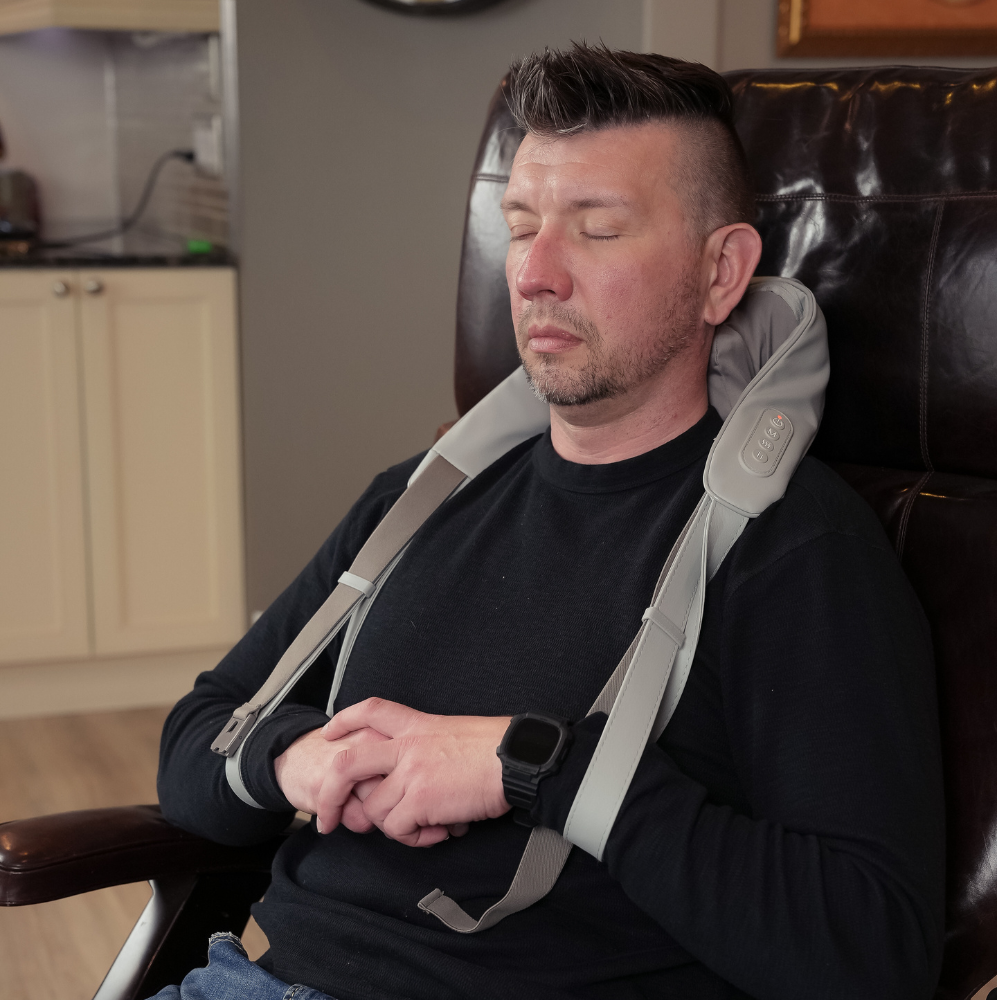 Man relaxing on chair with using the Backplus® Cordless Platinum Shiatsu Massager on his neck.