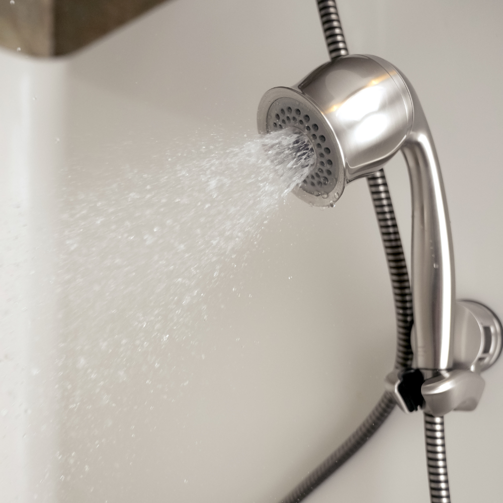 ShowerMe® Handheld Shower Head Brushed Nickel on shower wall with water sprayng