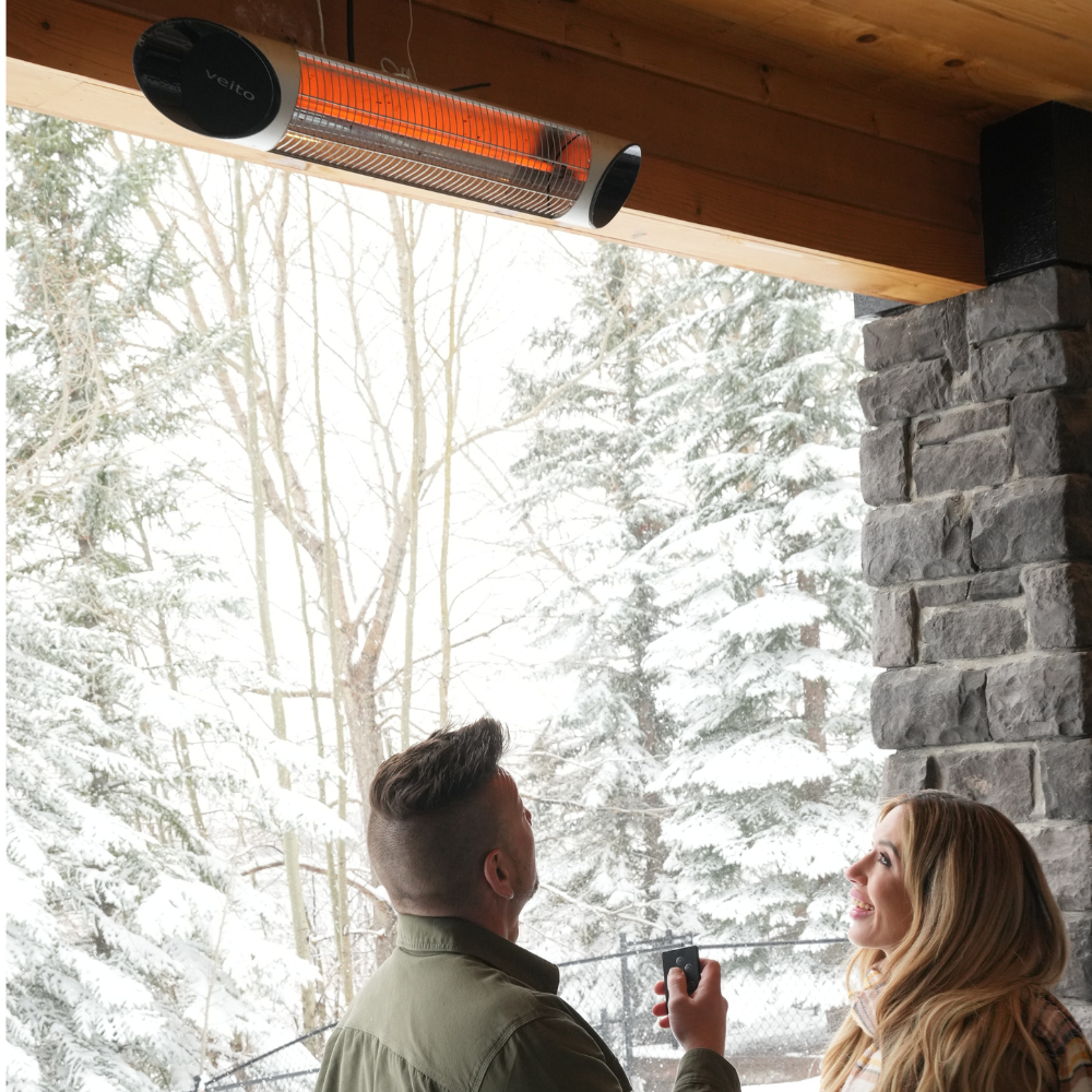 A couple looking at their Veito® Blade 1500W infrared Heater installed outside on the wall.