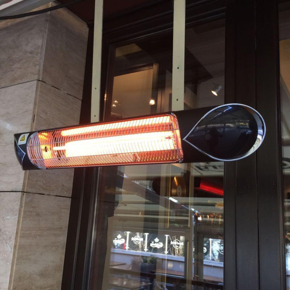 Wall-mounted iQ Heat® Wave infrared heater glowing orange, installed next to a glass door in an indoor or semi-outdoor area.