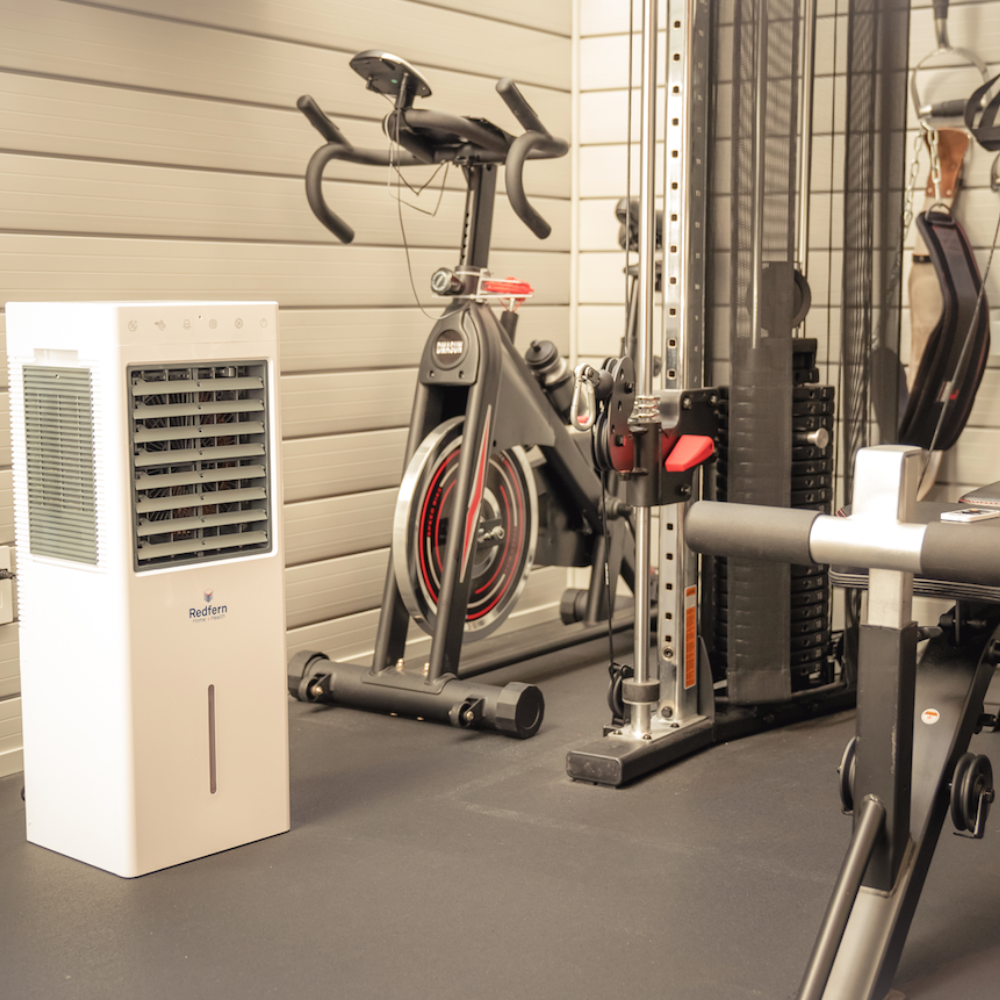 iQ Pure Breeze Air Cooler next to fitness equipment in workout room