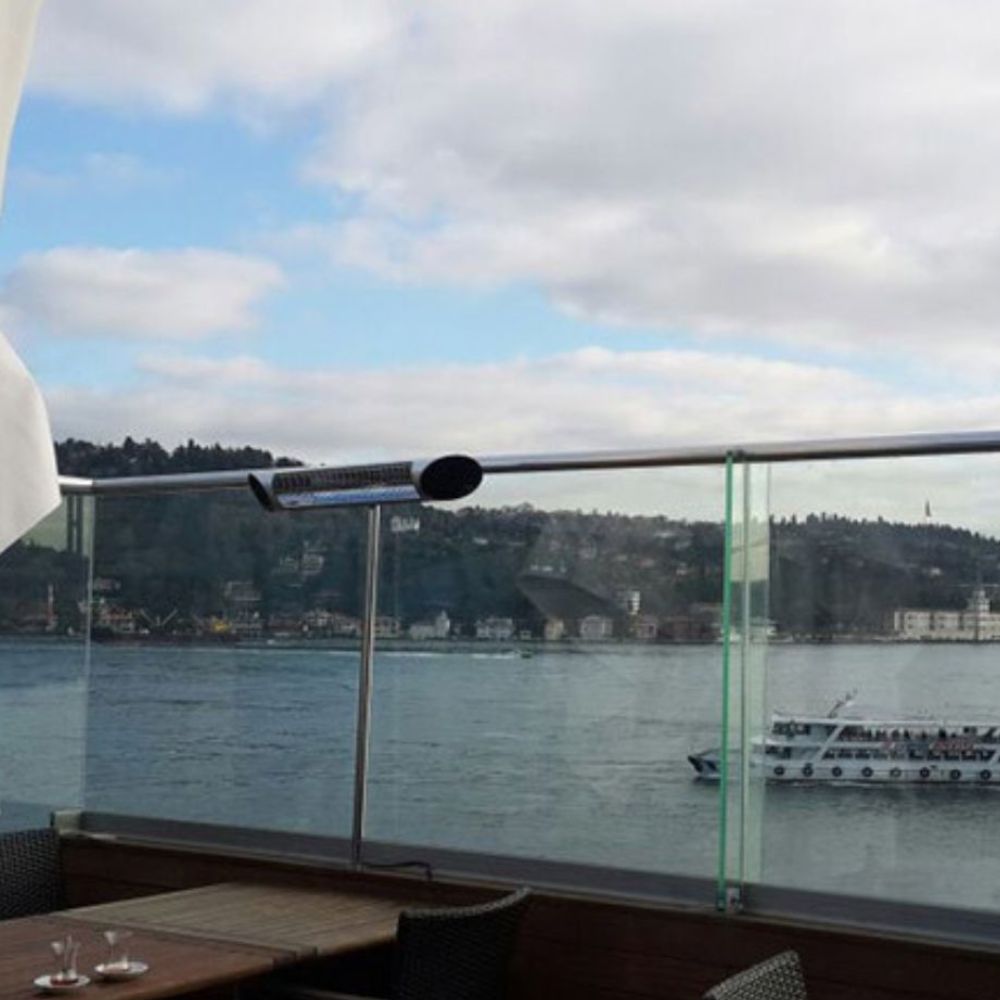 Image of a Veito Blade Heater mounted on a railing with a boat and water in the background