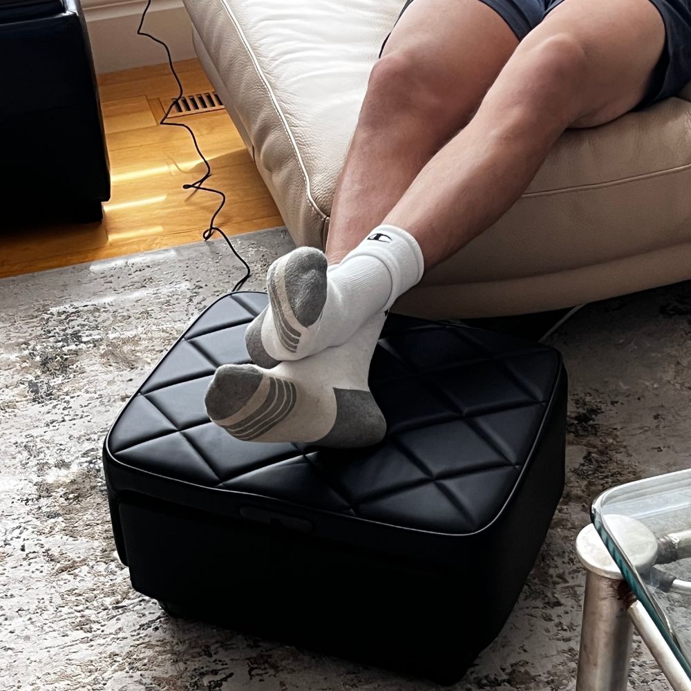 Close up of feet resting on BACKplus Ottoman Massager